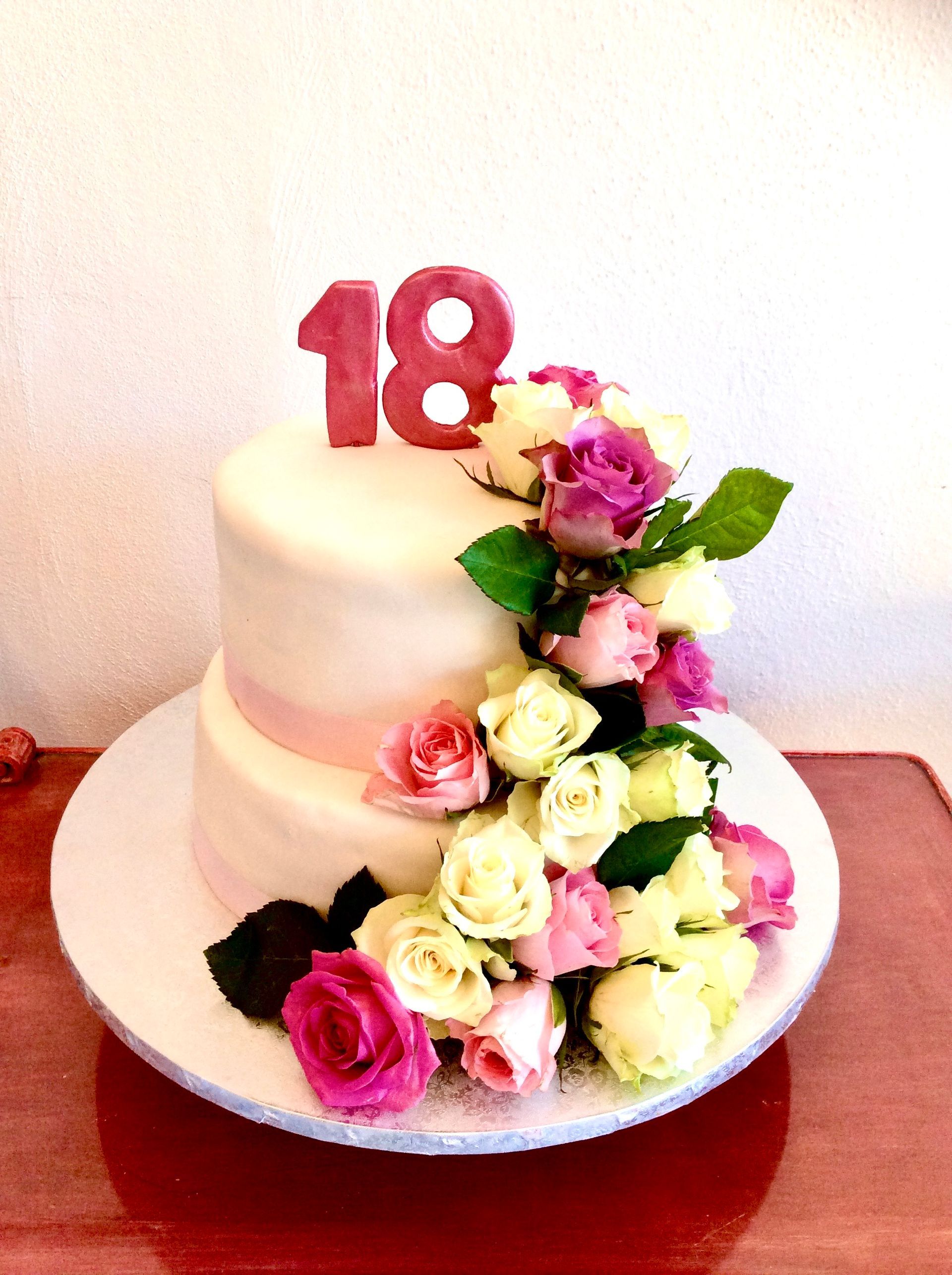 Una persona che indossa i guanti sta decorando una torta con i fiori.