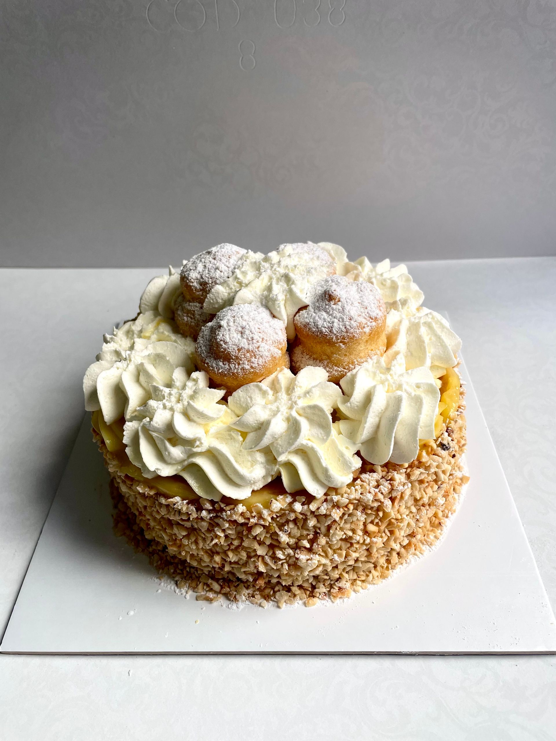 Una varietà di torte sono esposte su uno scaffale di vetro in una panetteria.