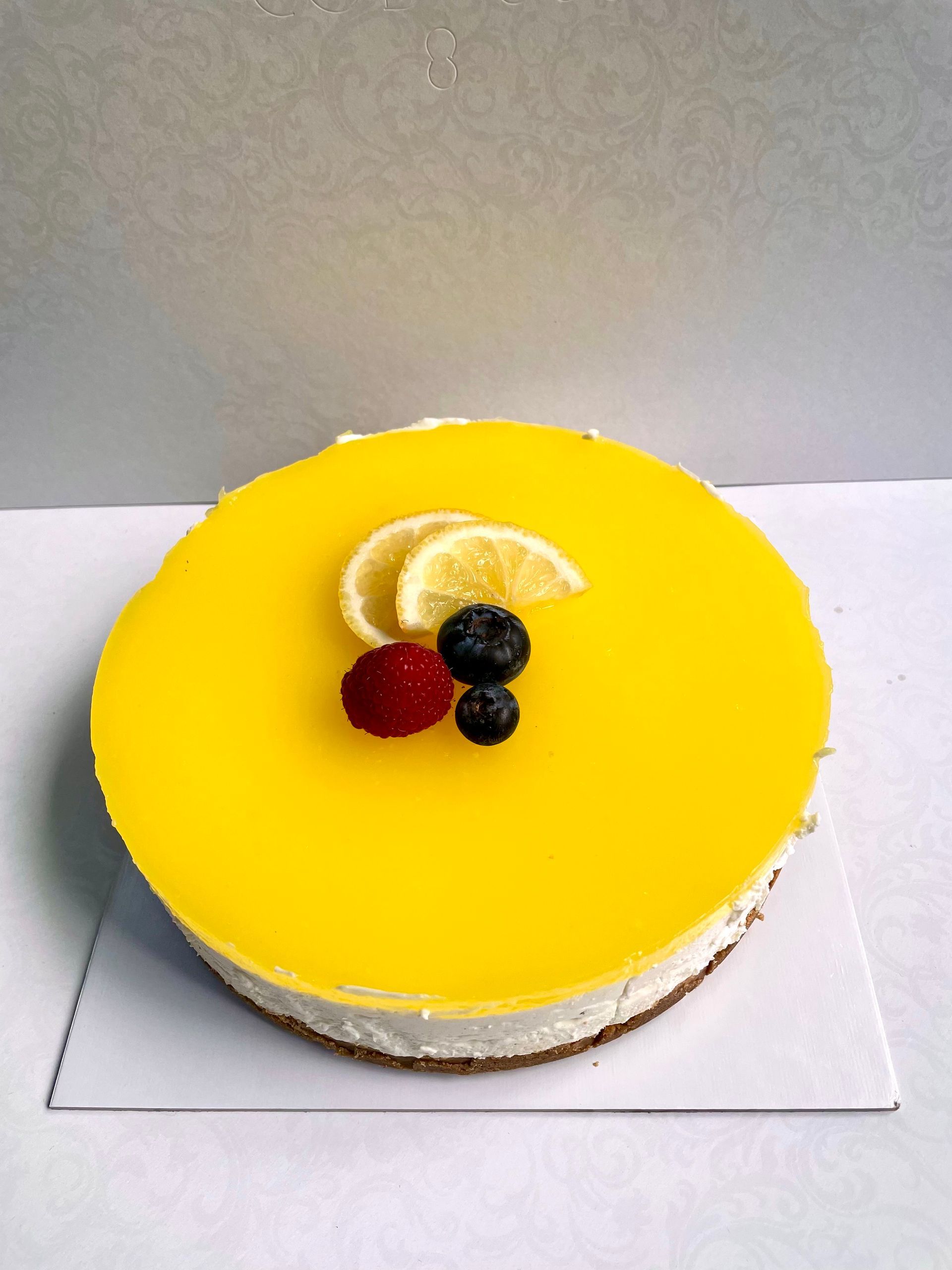 Una torta con sopra dei lamponi su un tavolo di legno