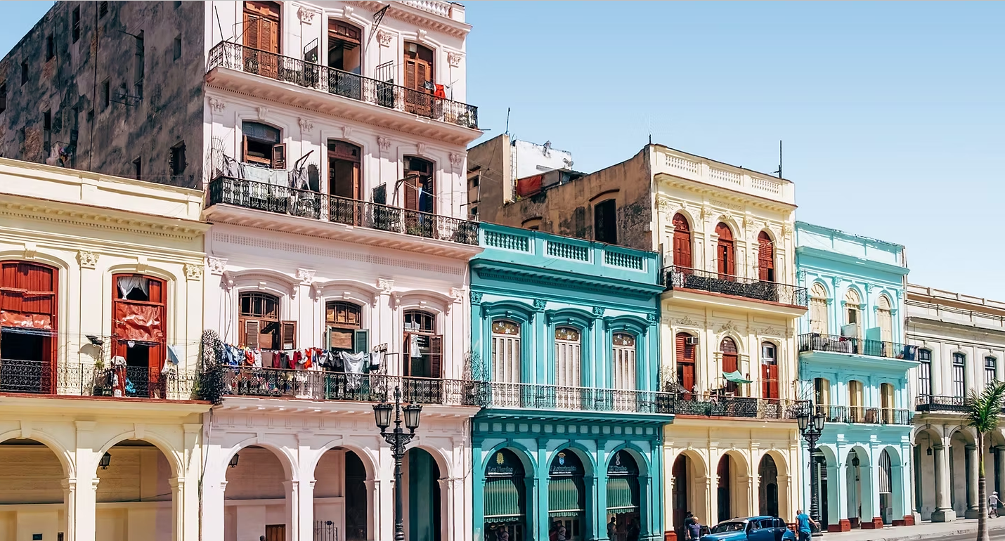 A row of colorful buildings are lined up on a city street.