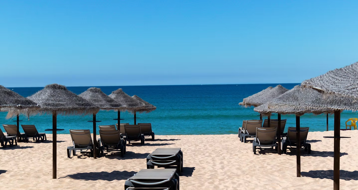 There are a lot of chairs and umbrellas on the beach.