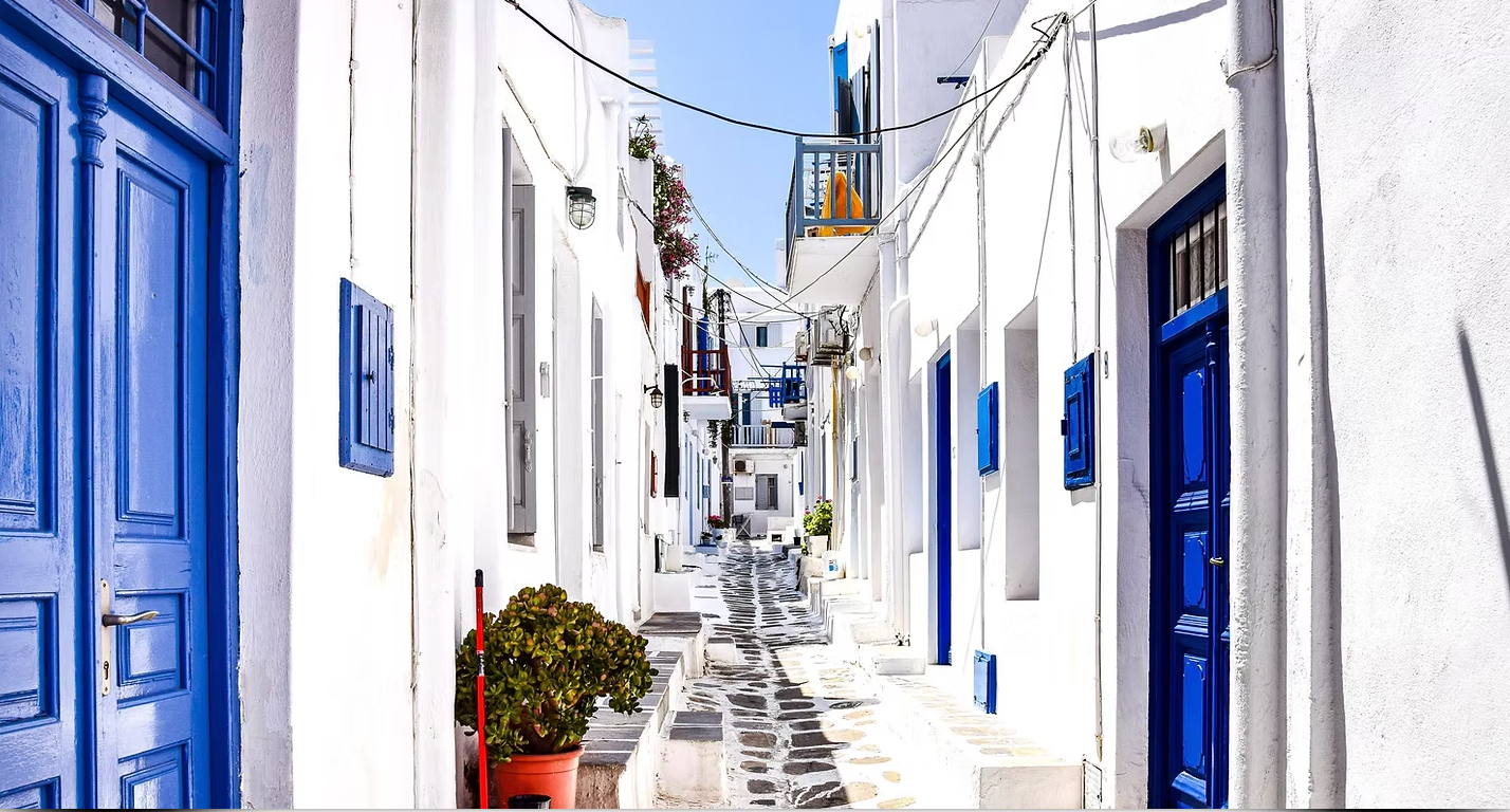 A narrow alleyway between two buildings with blue doors.