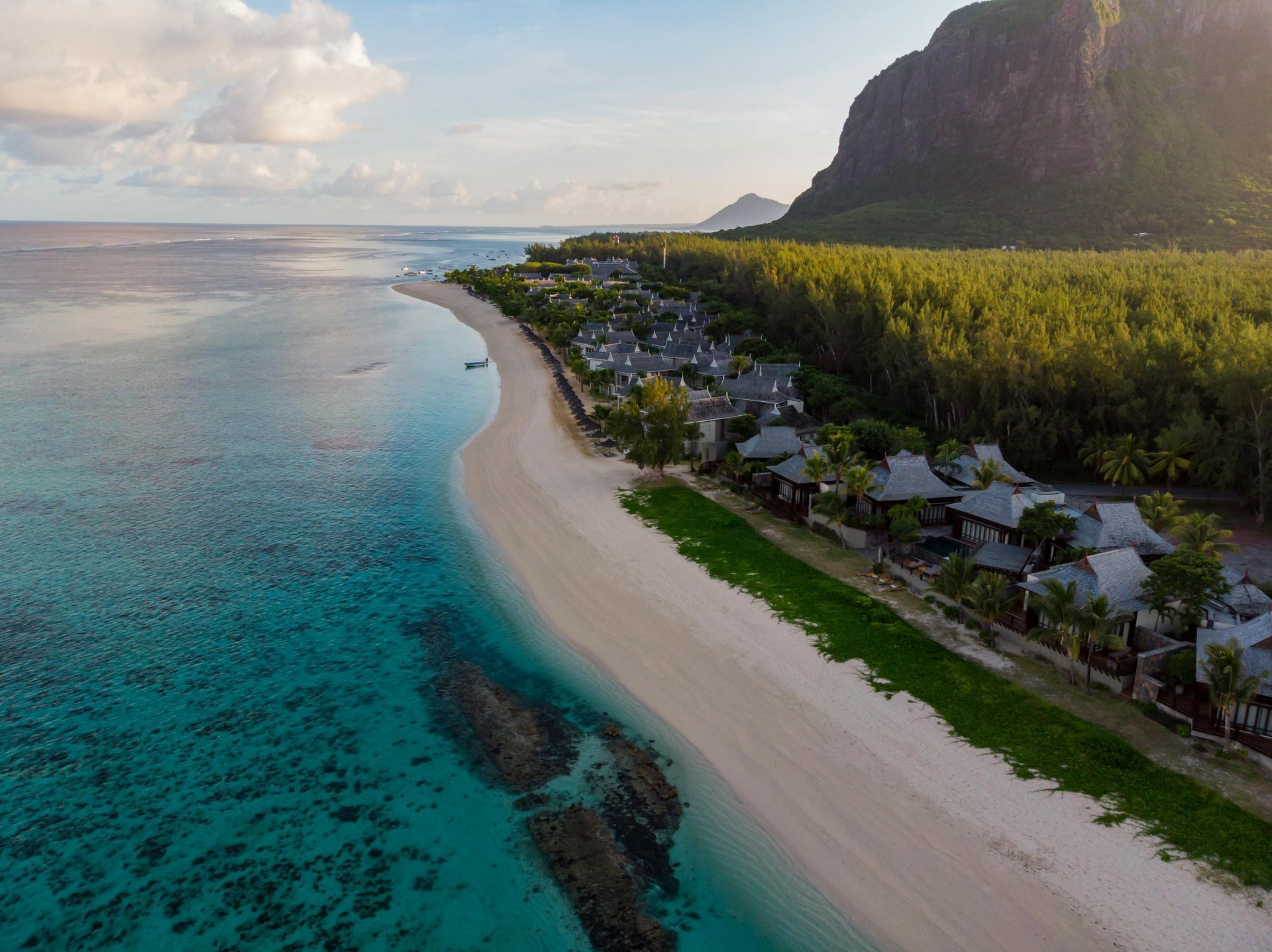 An aerial view of a beach with a mountain in the background.