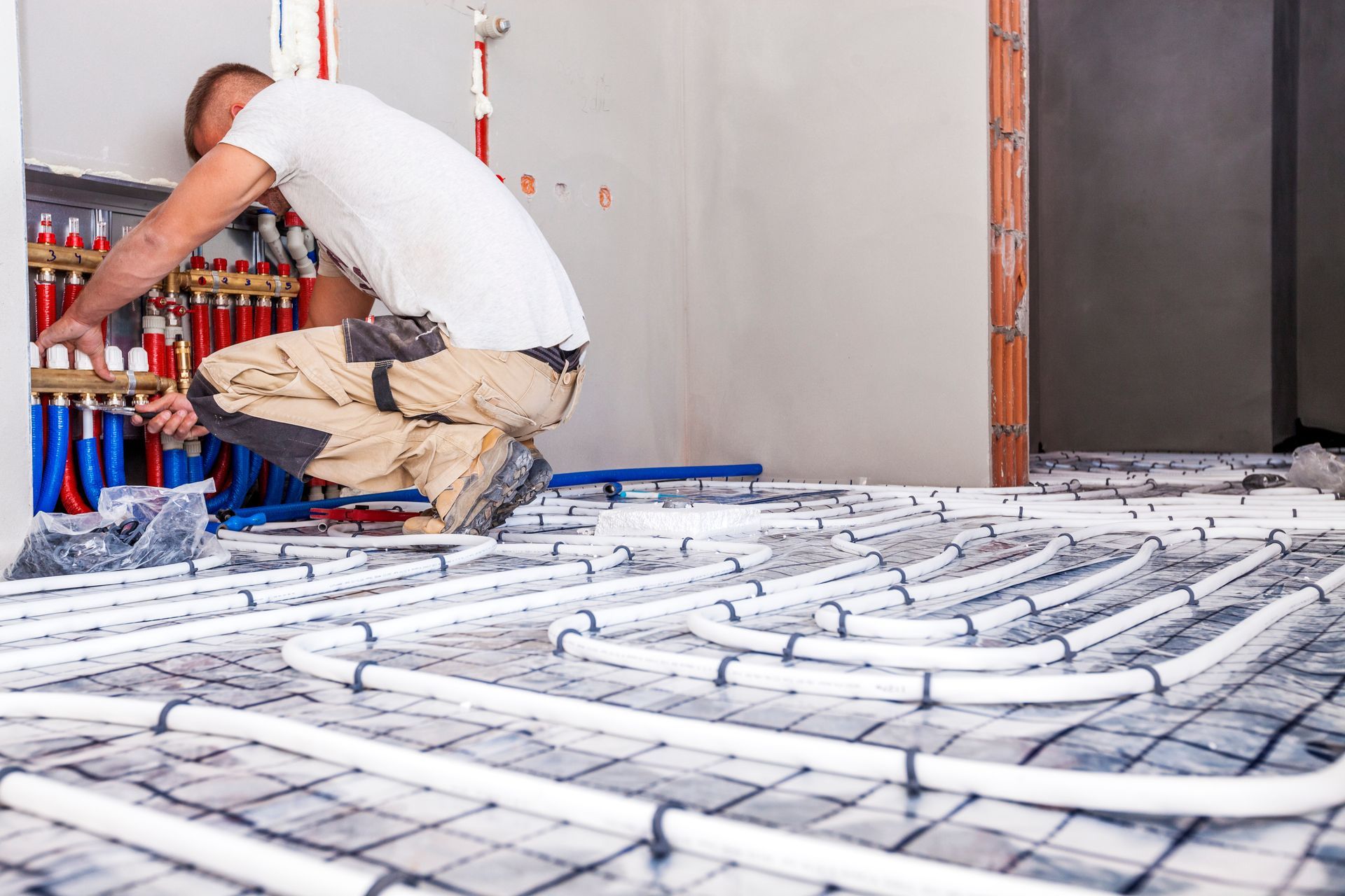 Chauffagiste installant un plancher chauffant.