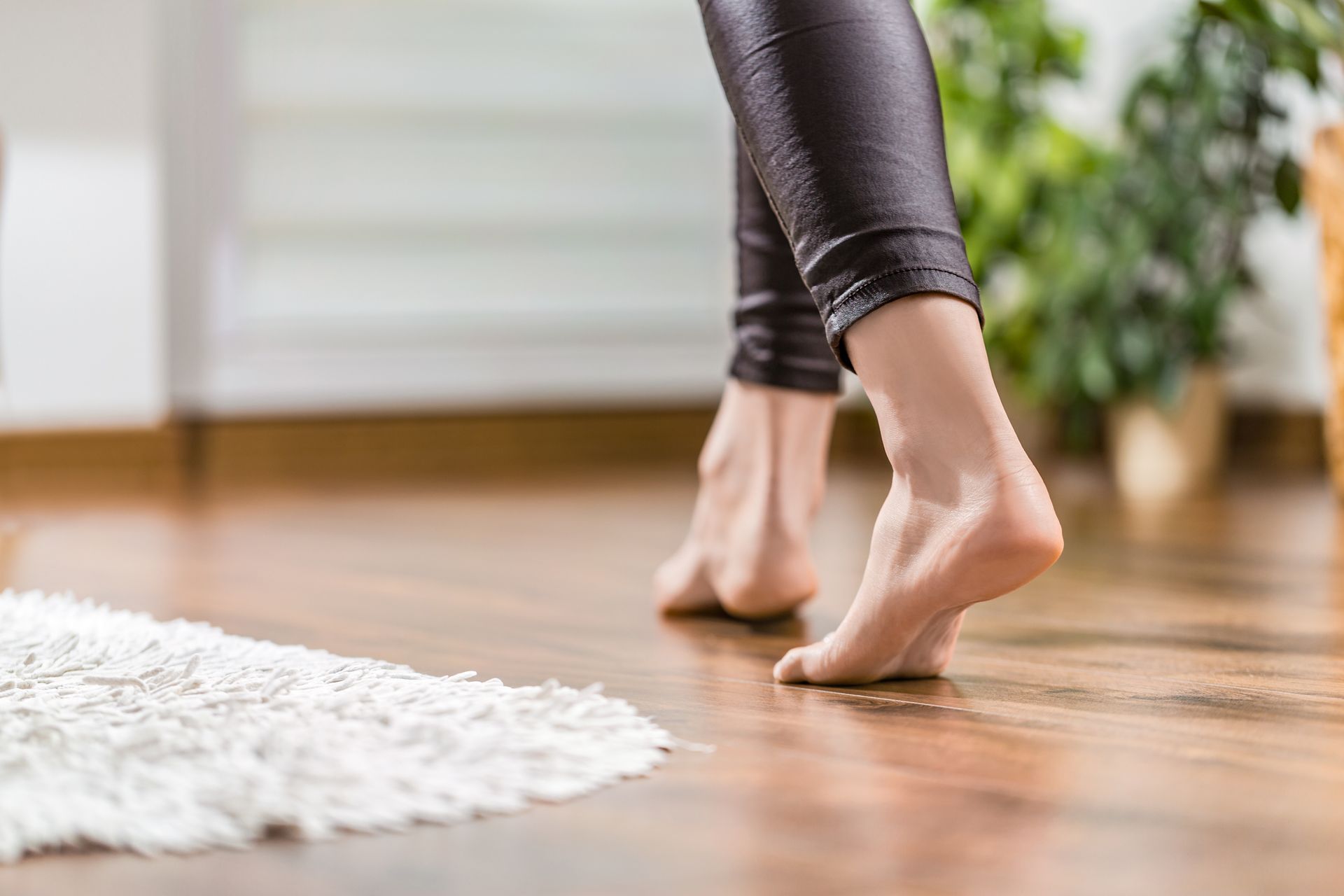 Femme marchant pieds nus chez elle.