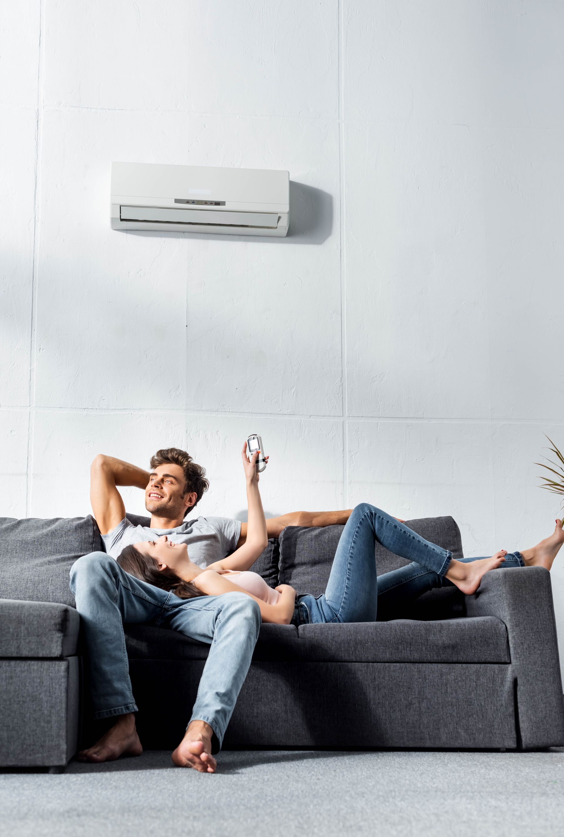 Couple sur un canapé sous la climatisation.