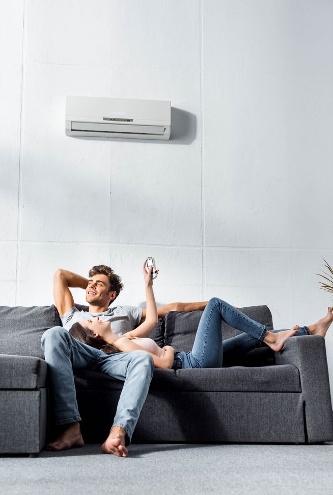 Couple sur un canapé sous la climatisation.
