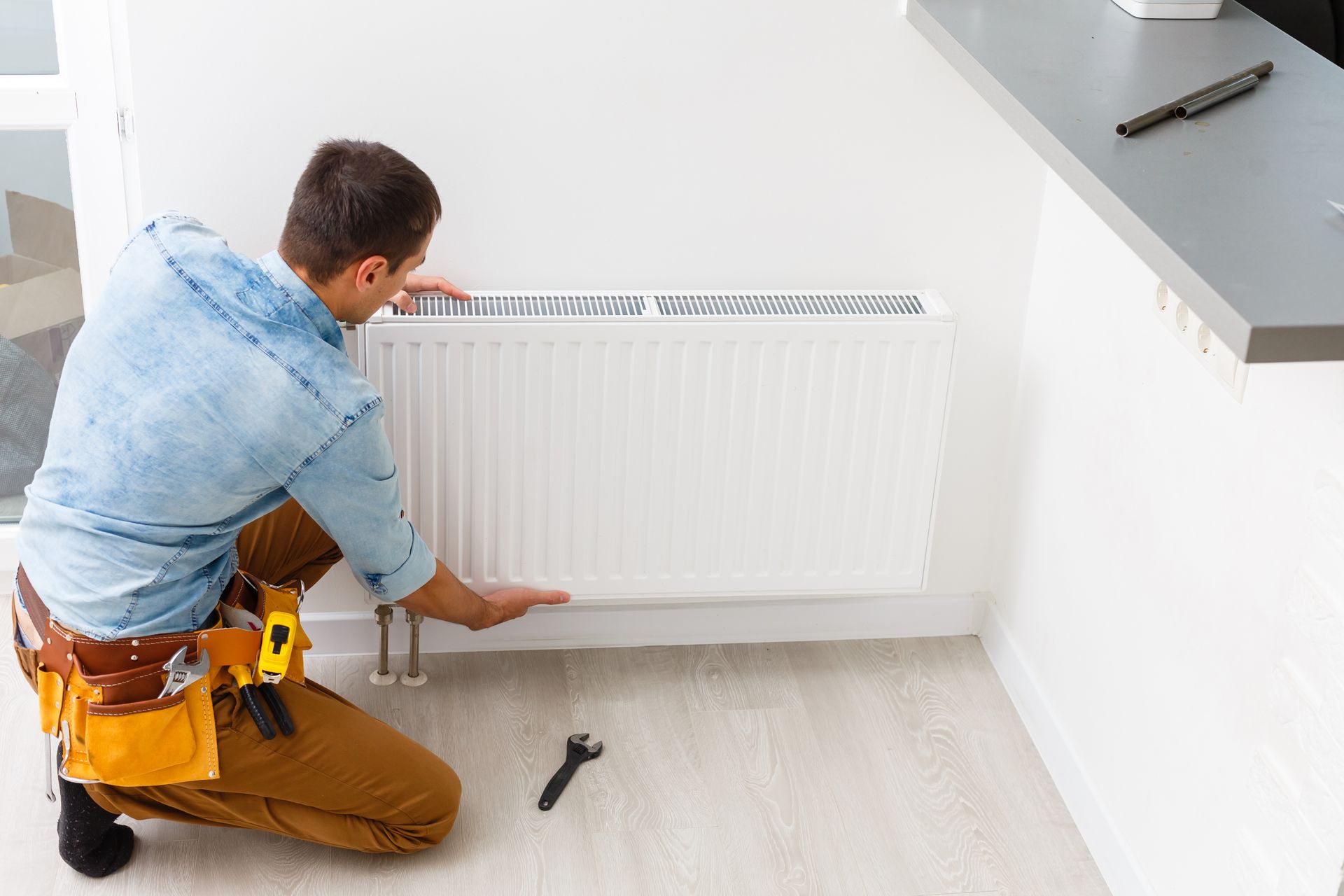 Chauffagiste remplaçant un radiateur.