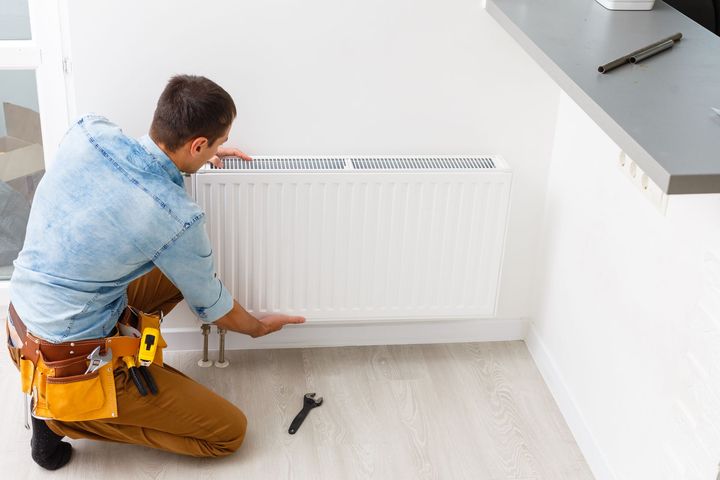 Chauffagiste remplaçant un radiateur.
