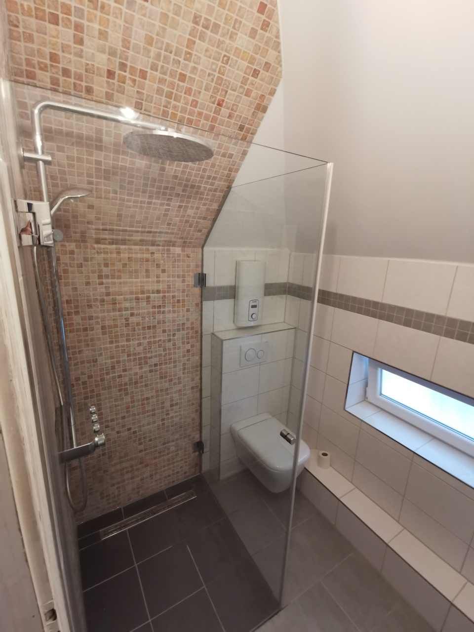 Dusche mit Glasabtrennungen und gekachelter Rückwand