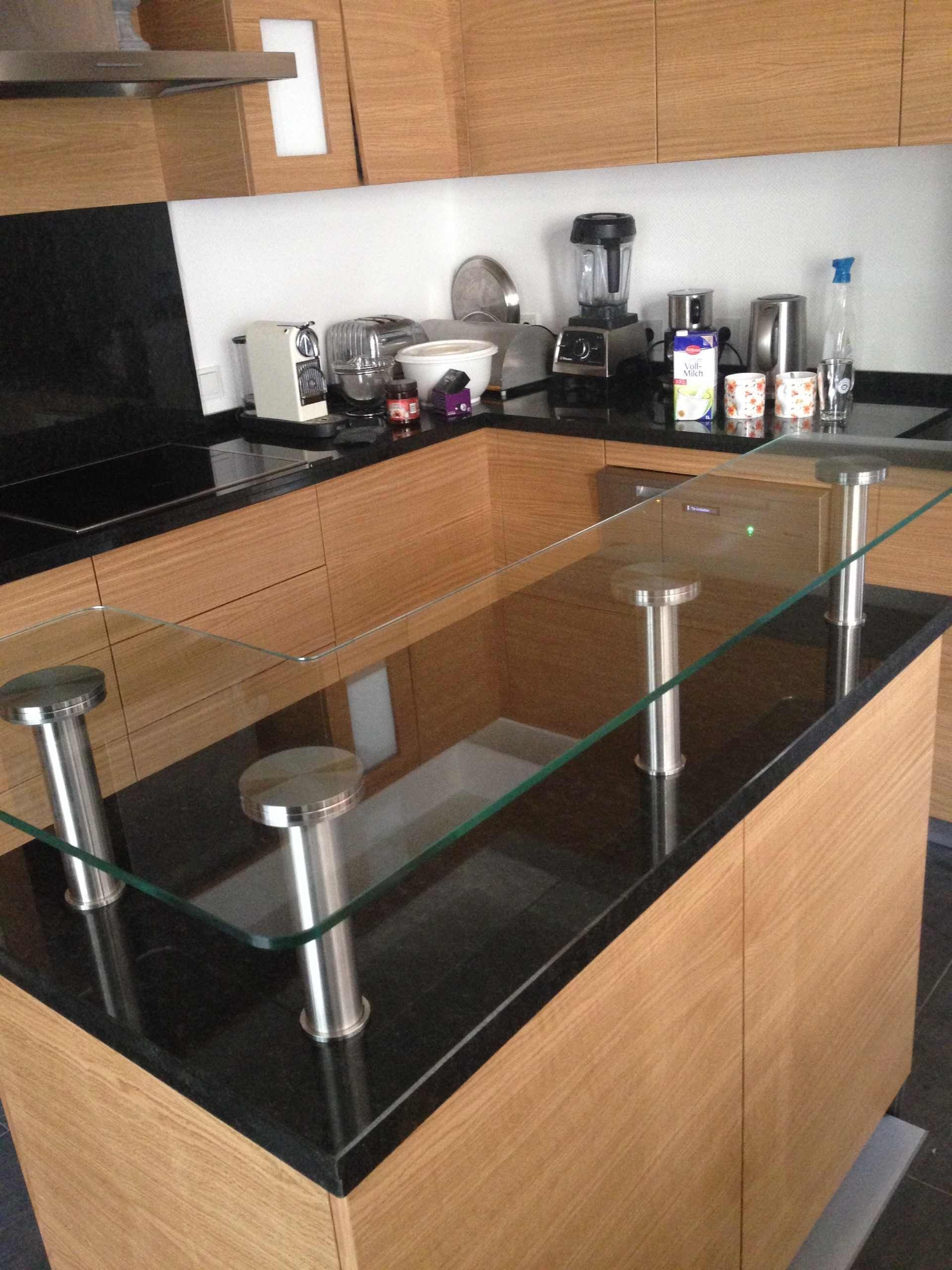 Eine Küche mit Glasarbeitsplatte und Holzschränken