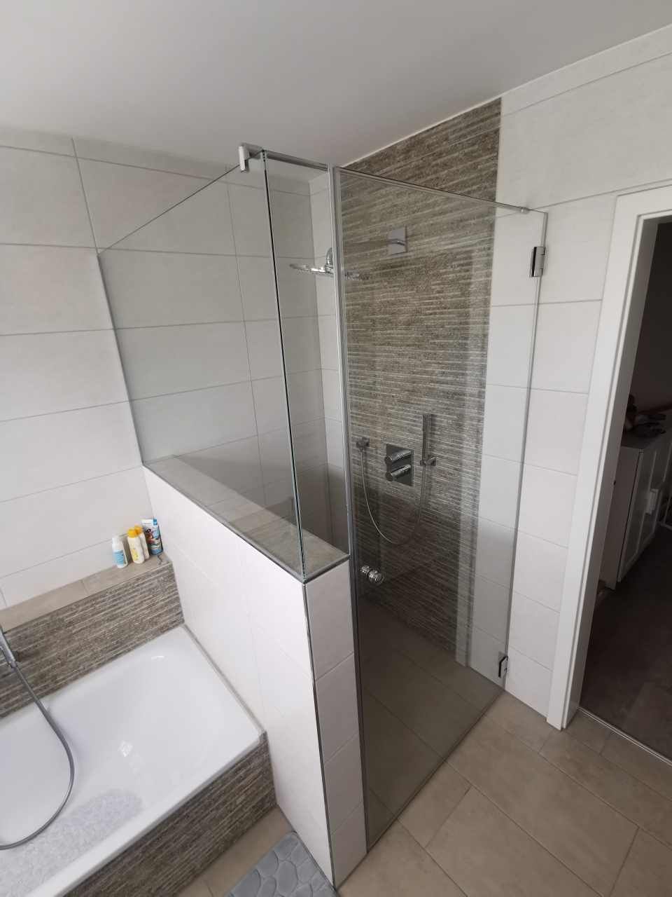 Ein modernes Badezimmer mit ebenerdiger Dusche und Glaswänden.