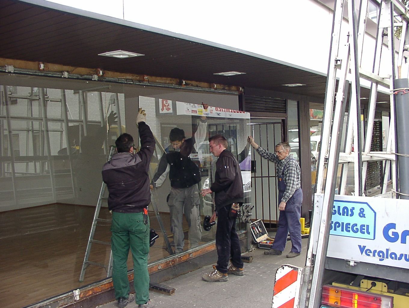 Männer installieren neue Schaufenster an einem Laden