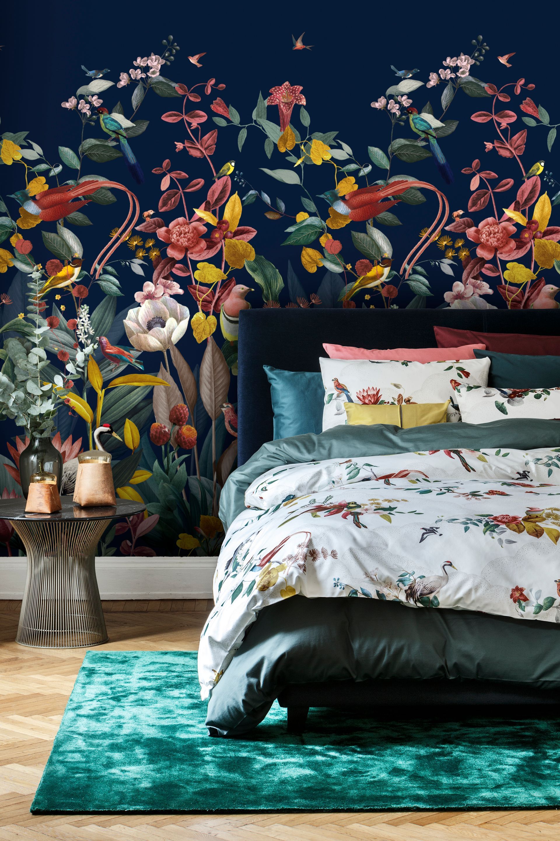 Schlafzimmer mit floraler Tapete, türkisfarbenem Teppich und Bettwäsche in Weiß, mit Blumenmuster und Türkis.