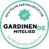 Rundes, hellgrünes Abzeichen mit der Aufschrift „GARDINEN.DE“ und deutschem Text, das die Mitgliedschaft in einem Qualitätsverband kennzeichnet.