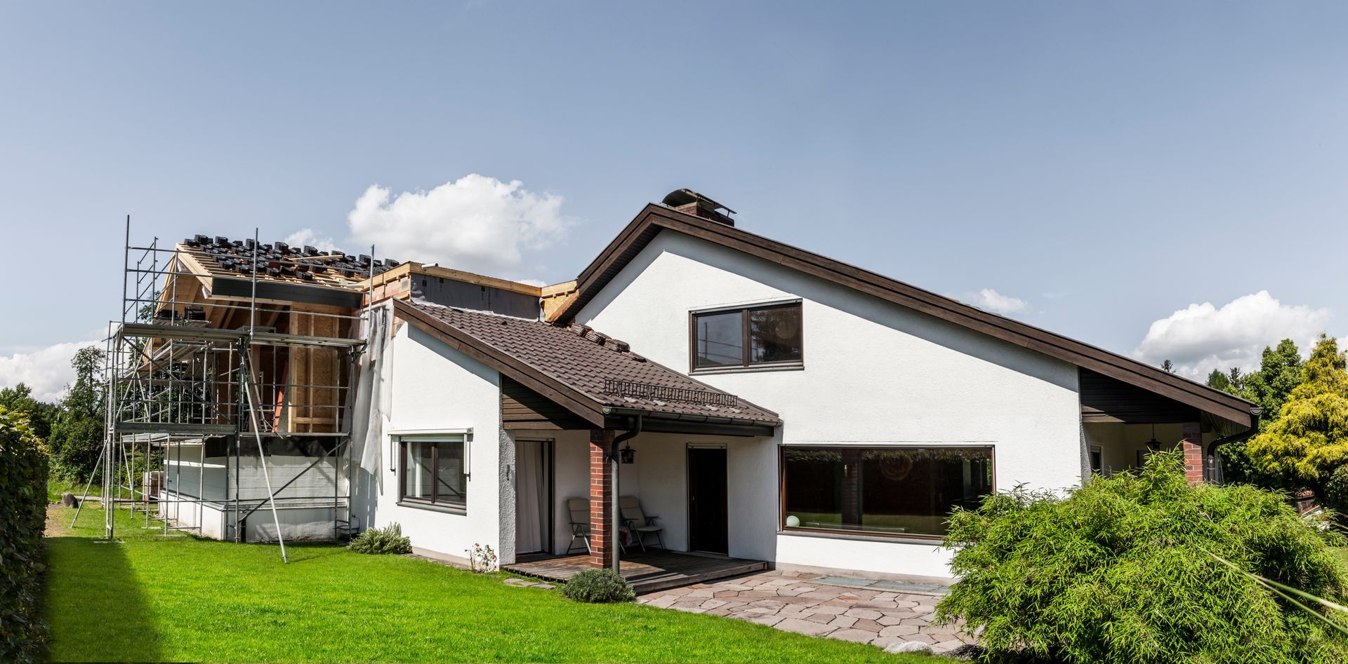 Une maison blanche avec des échafaudages sur la gauche : des travaux d'extension sont en cours.