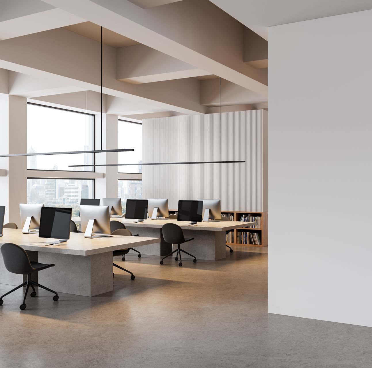 Un bureau moderne à plan ouvert avec des bureaux, des chaises pivotantes et de grandes fenêtres.