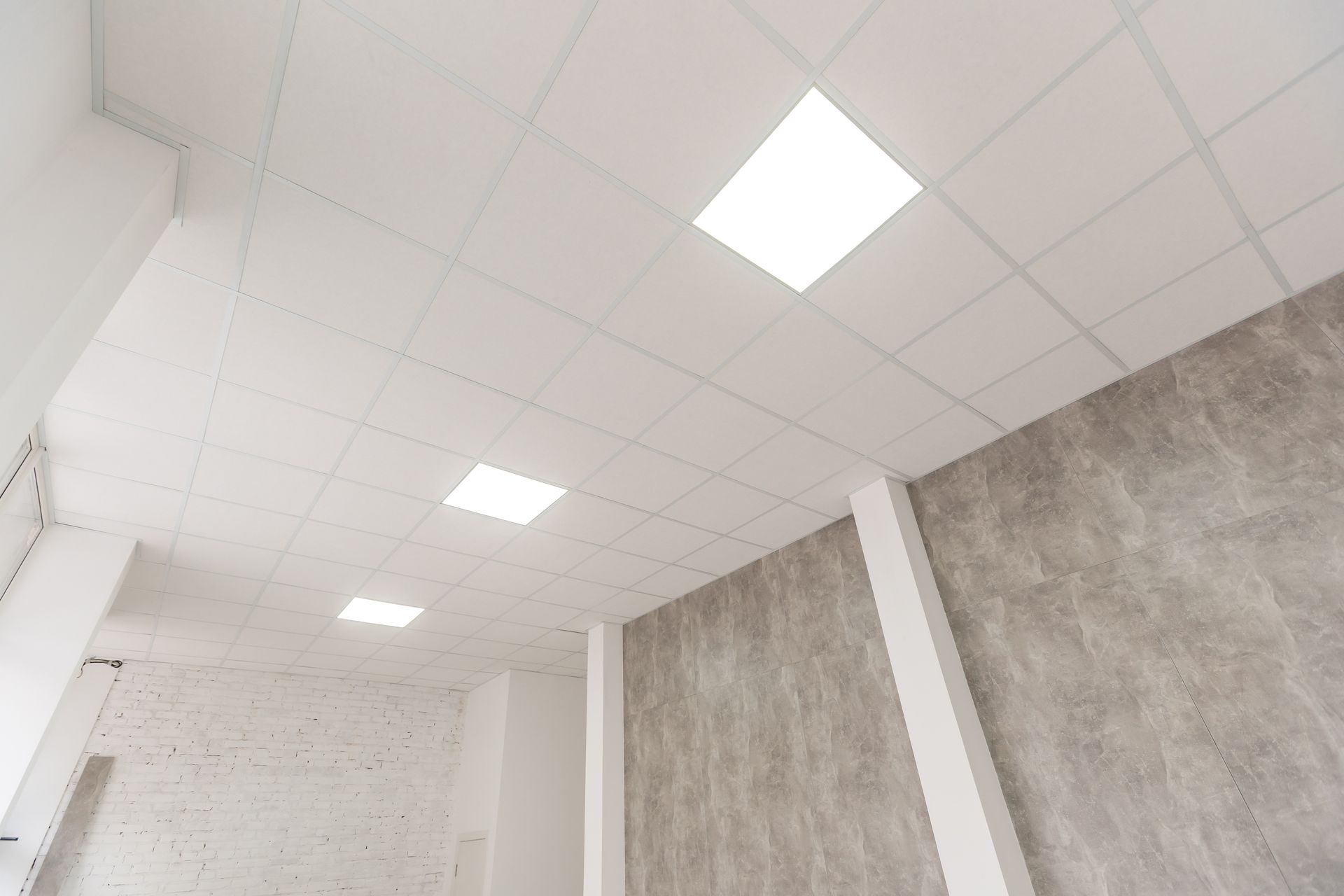Un plafond en dalles avec un éclairage encastré.