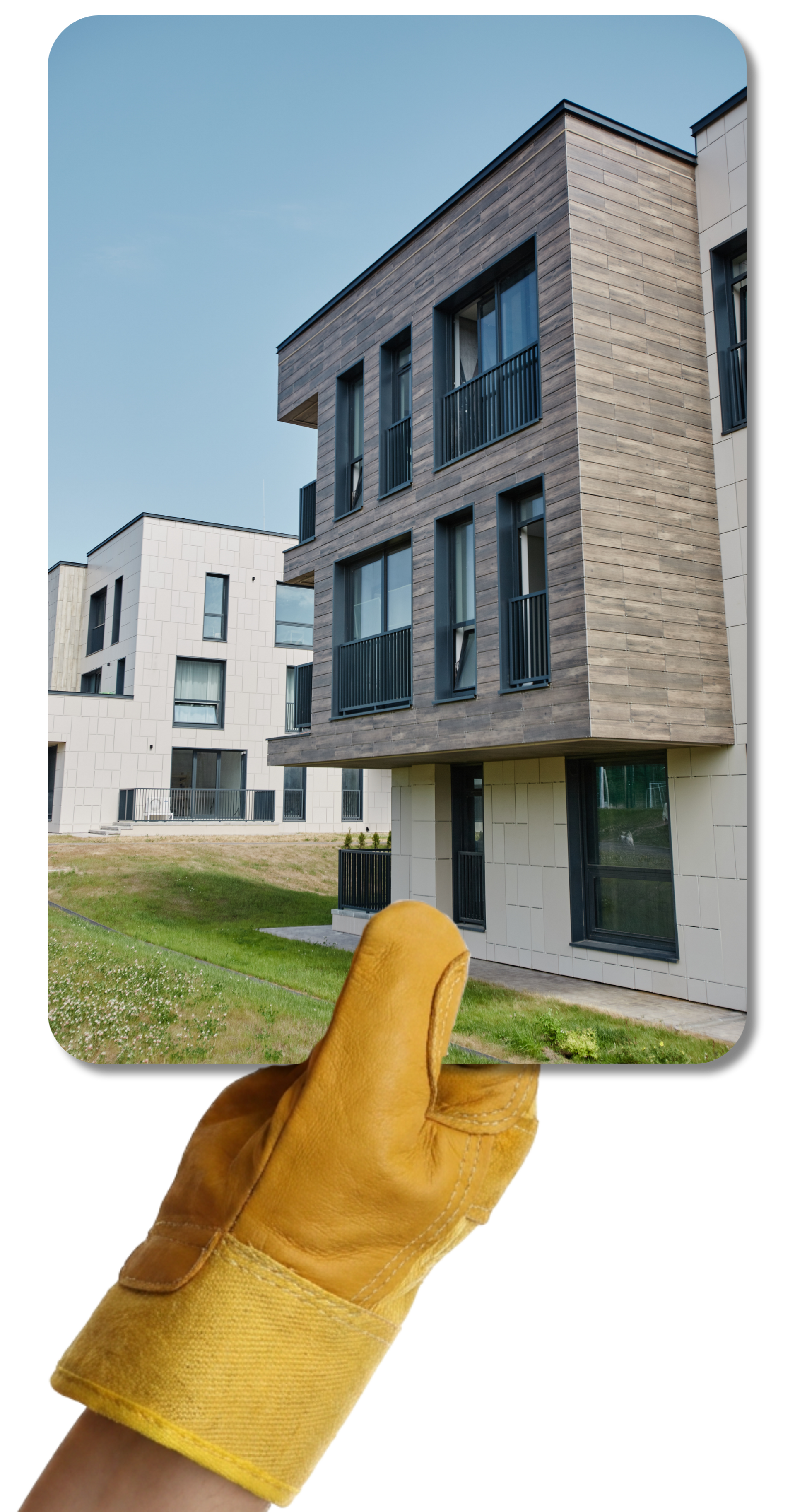 Une main gantée de jaune tient une photo d'un bâtiment moderne, avec un ciel bleu en fond.