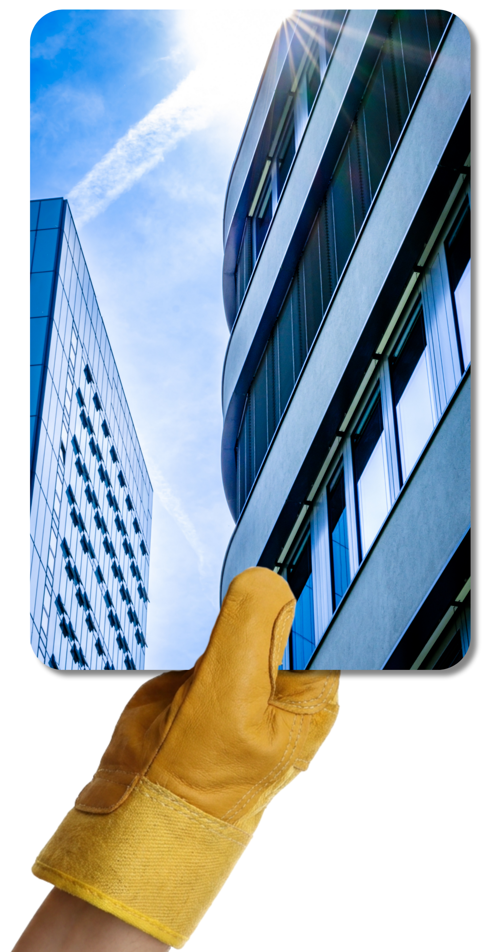Une main gantée de jaune tient une photo d'un bâtiment professionnel moderne, prise en contreplongée.