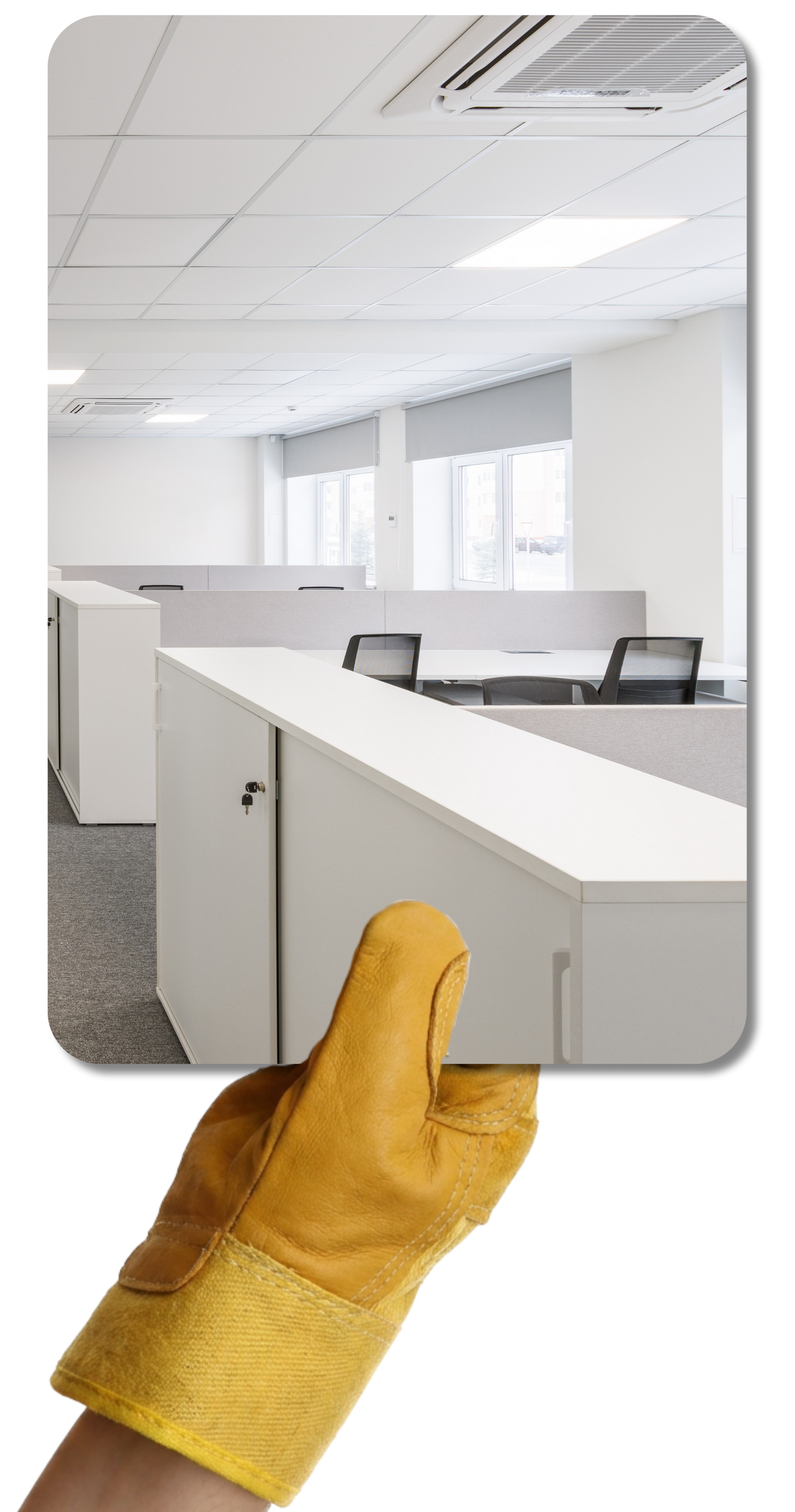 Une main gantée de jaune tient une photo d'un espace de bureaux avec un plafond en dalles.