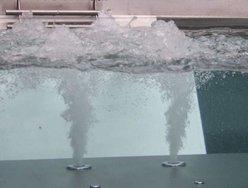 Eine Nahaufnahme eines Schwimmbeckens aus Edelstahl, aus dem Blasen aufsteigen. Foto von der Artmetal GmbH