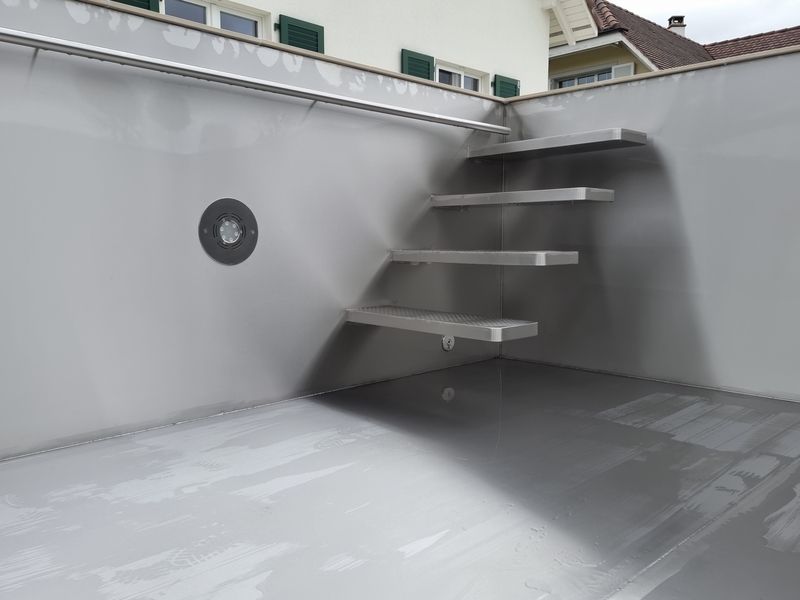 Eine Edelstahltreppe, die zu einem Swimmingpool führt. Foto von der Artmetal GmbH