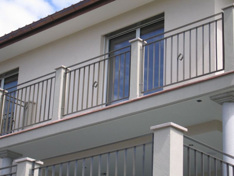 Ein weisses Haus mit einem Balkon mit Metallgeländer. Foto von der Artmetal GmbH