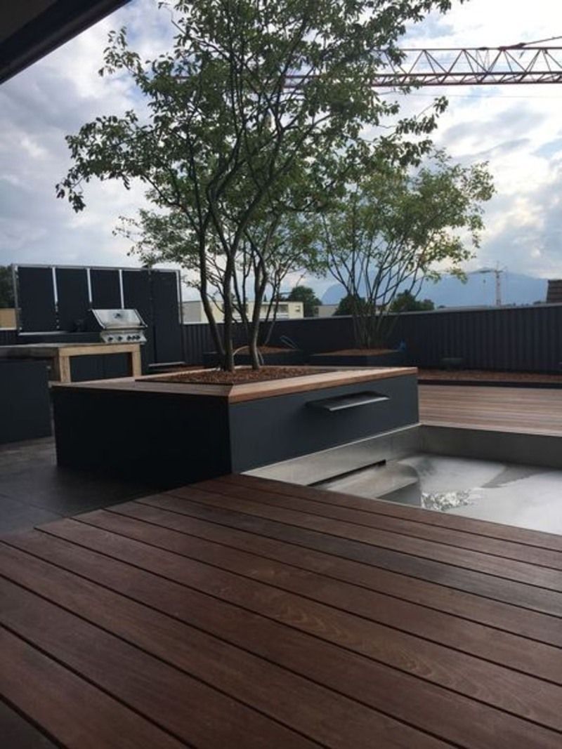 Ein Holzdeck mit einem Baum in der Mitte. Foto von der Artmetal GmbH