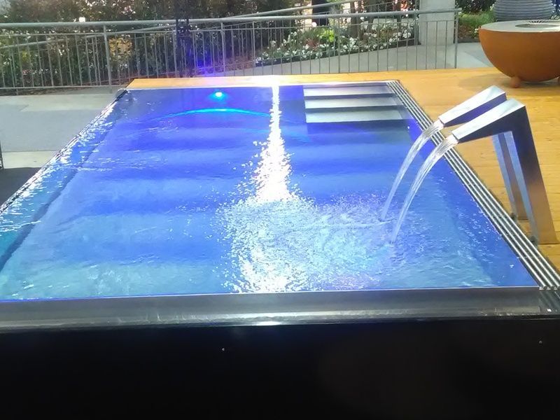 Ein grosses Schwimmbecken aus Edelstahl mit blauen Lichtern darauf. Foto von der Artmetal GmbH