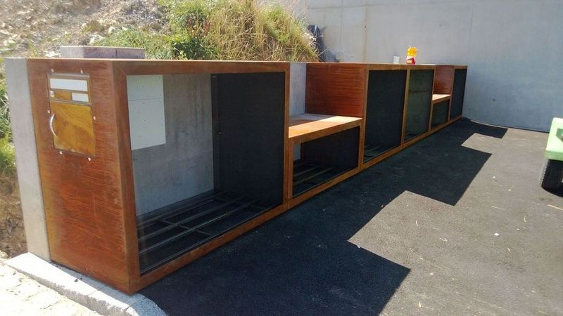 Eine Reihe Holzkisten auf einer Betonfläche. Foto von der Artmetal GmbH