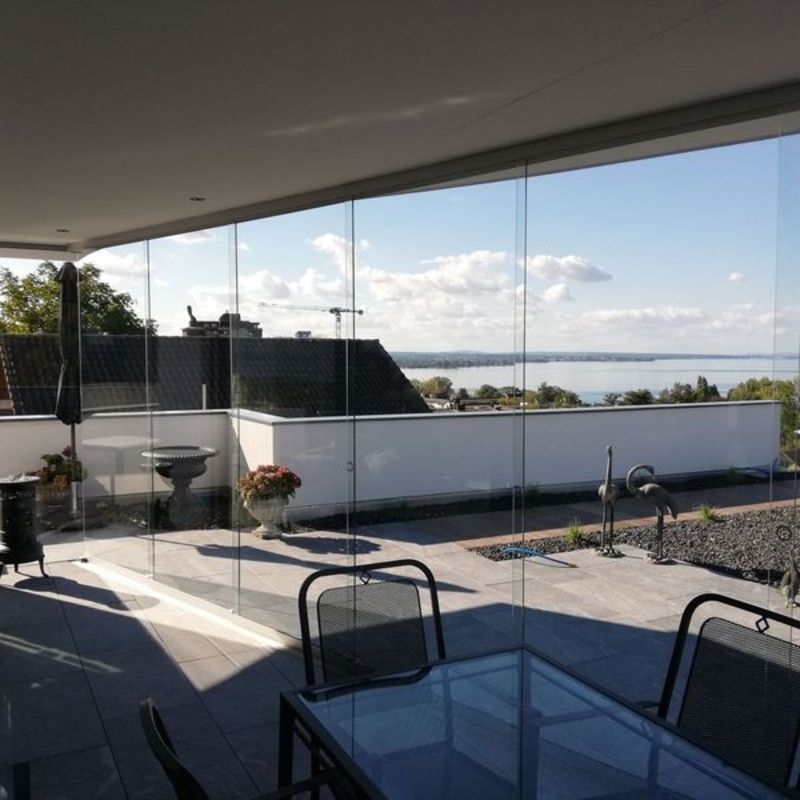 Eine Terrasse mit Tisch und Stühlen und Blick auf ein Gewässer. Foto von der Artmetal GmbH