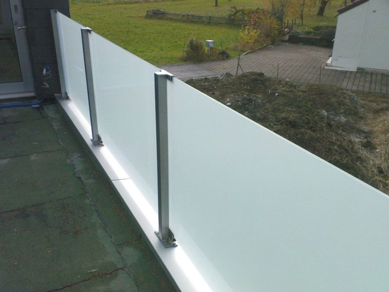 Ein Balkon mit Glasgeländer und Blick auf ein Feld. Foto von der Artmetal GmbH