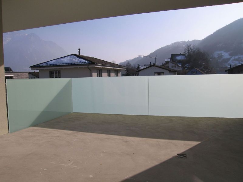 Ein Balkon mit Blick auf ein Haus und die Berge. Foto von der Artmetal GmbH