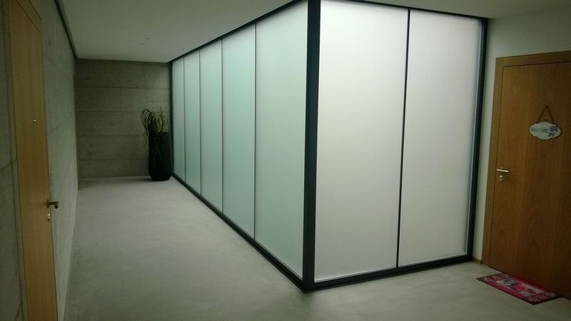 Ein langer Flur mit weissen Wänden und einer Tür. Foto von der Artmetal GmbH