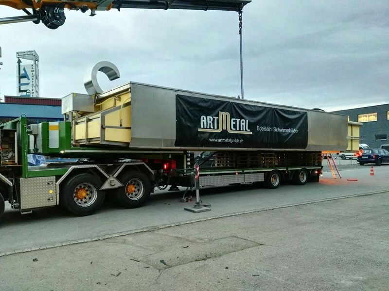Ein grosser Kunst-Metall-LKW wird von einem Kran angehoben. Foto von der Artmetal GmbH