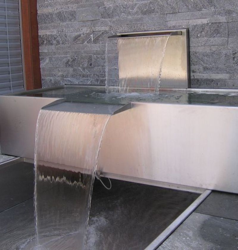 Ein Edelstahlbrunnen, aus dem Wasser kommt. Foto von der Artmetal GmbH