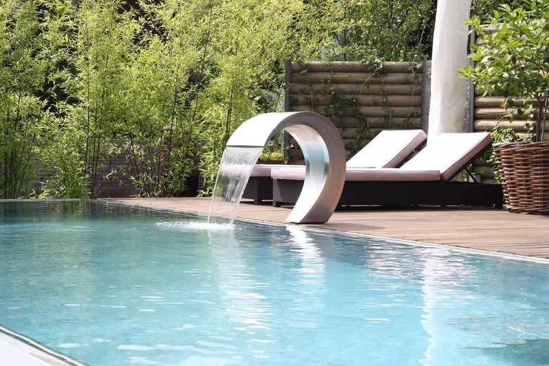 Ein Swimmingpool mit einem Wasserfall in der Mitte. Foto von der Artmetal GmbH