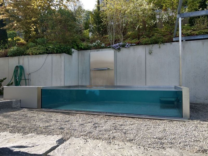 Ein grosser Swimmingpool mit Wasserfall im Hinterhof. Foto von der Artmetal GmbH