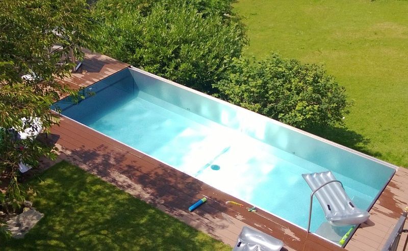 Eine Luftaufnahme eines Swimmingpools aus Edelstahl in einem Garten. Foto von der Artmetal GmbH