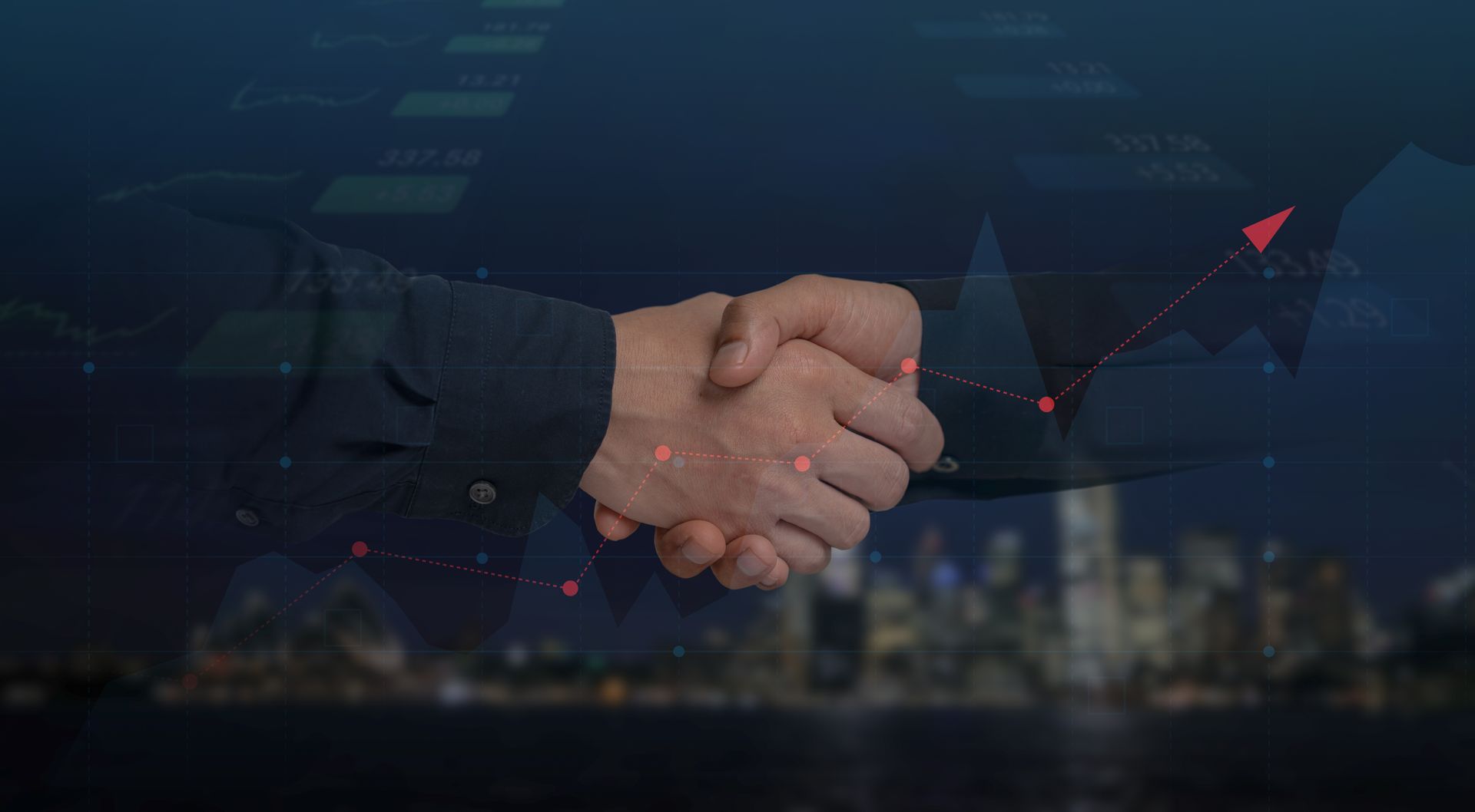 Dos hombres de negocios se dan la mano frente al horizonte de una ciudad.