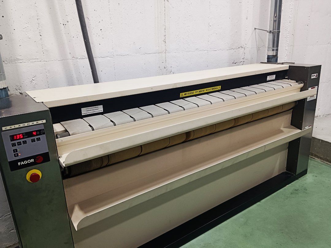 Una máquina grande está sentada sobre un piso verde en una habitación.