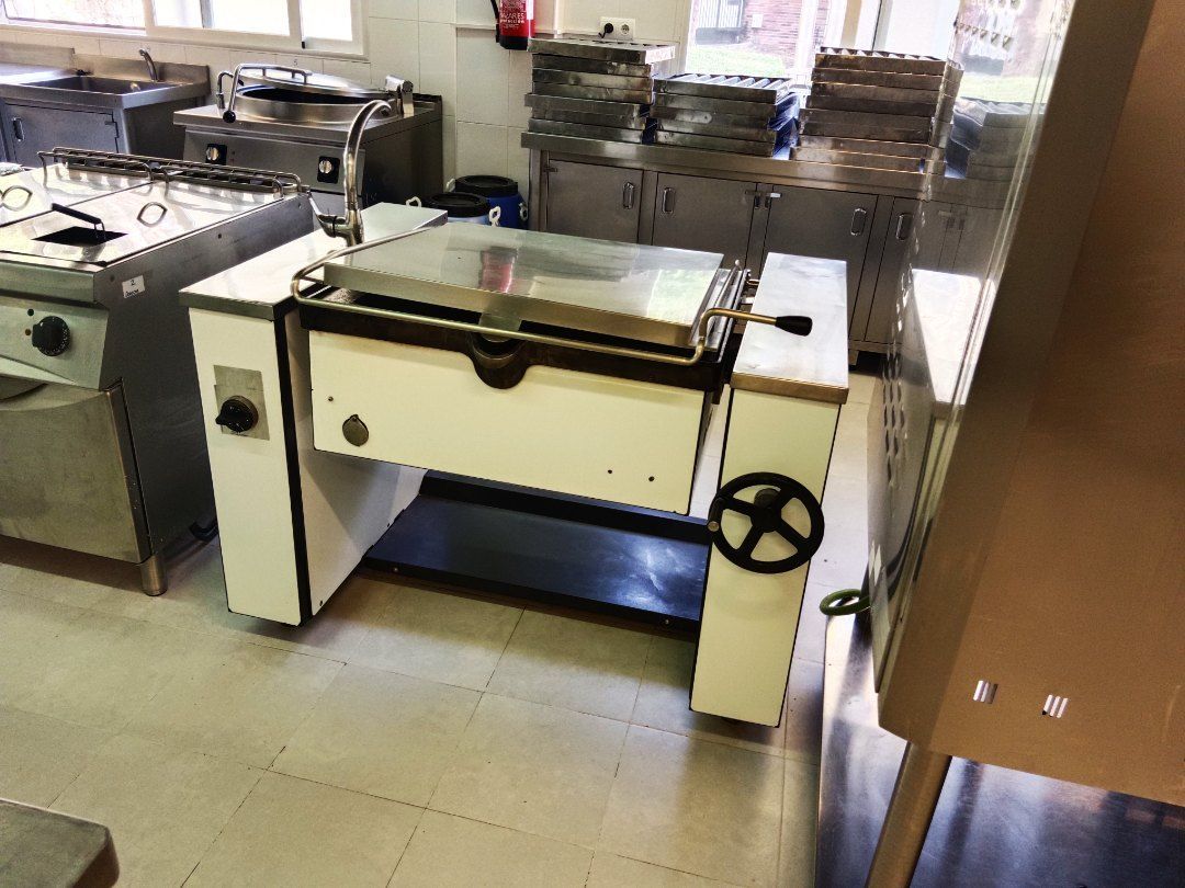 Una cocina con electrodomésticos de acero inoxidable y una máquina con una rueda encima.