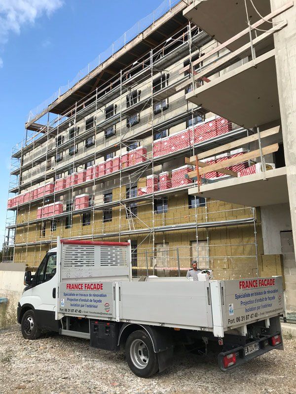 Façade d'un immeuble avec un échafaudage et le camion de France Façades