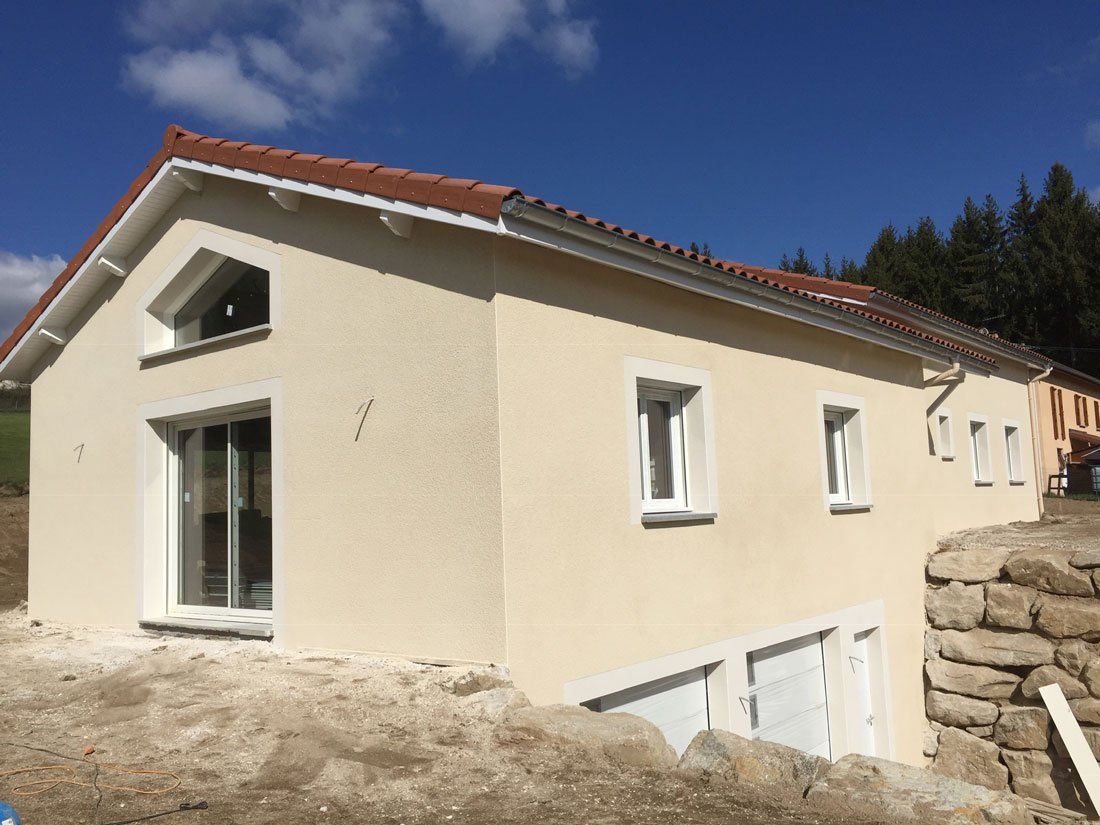 Maison avec deux niveaux d'accès et deux garages - enduit clair