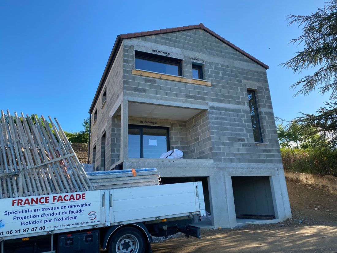 Maison neuve sans enduit avec brique apparente et camion France Façades devant