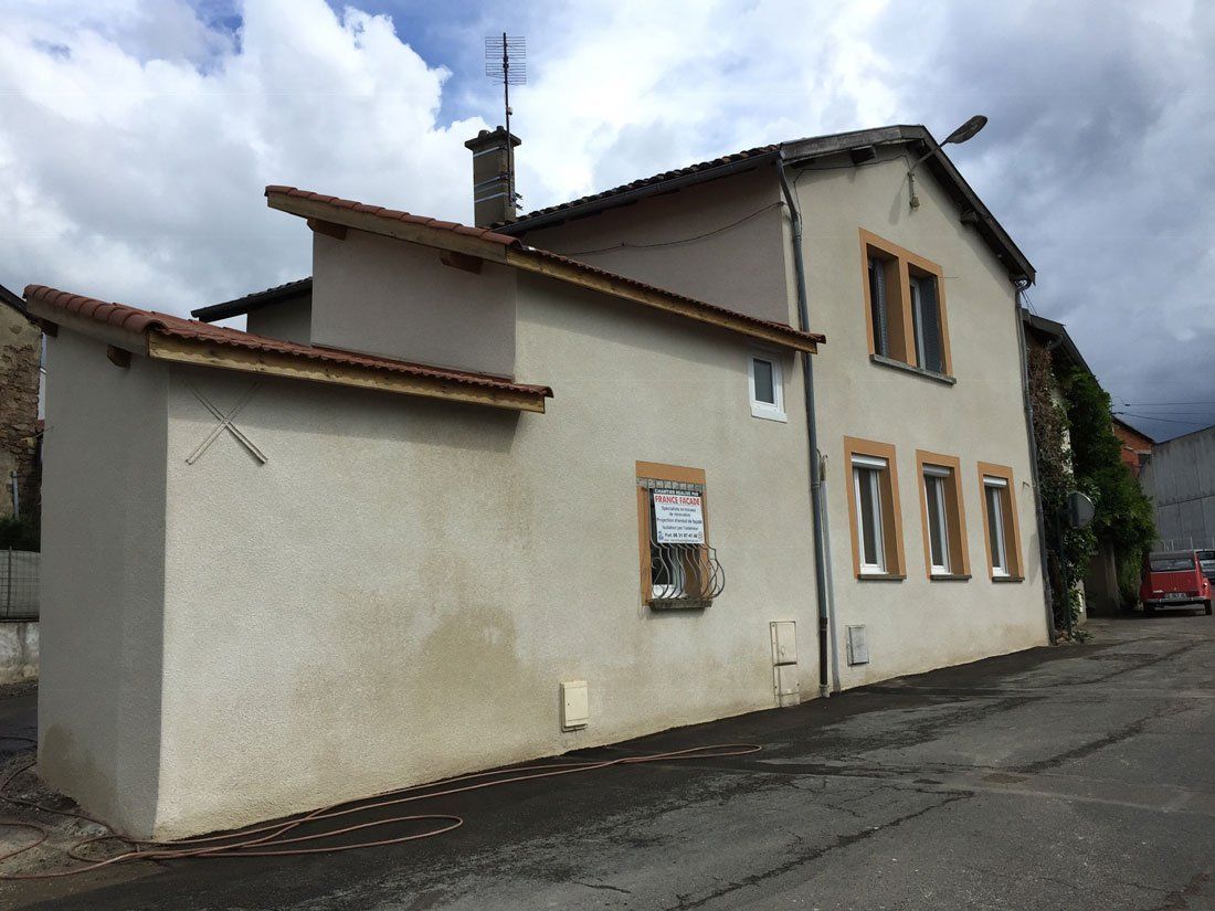 Maison de village avec toit en escalier dont l'enduit a été refait