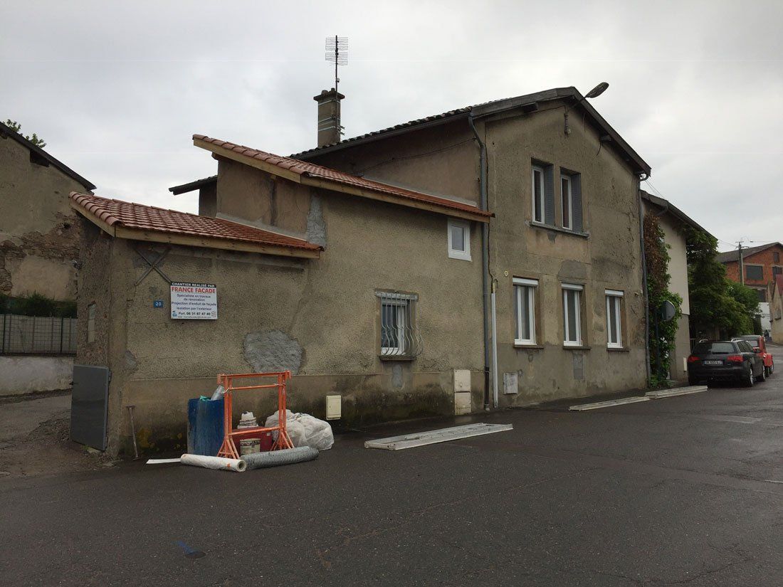 Maison de village avec toit en escalier dont la façade est très abîmée