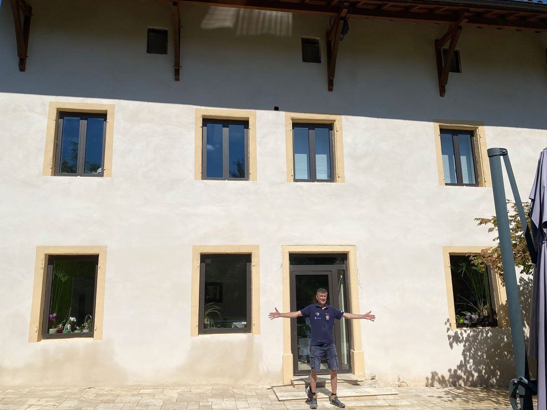 Maison avec façade neuve et ouvrier fier de son travail