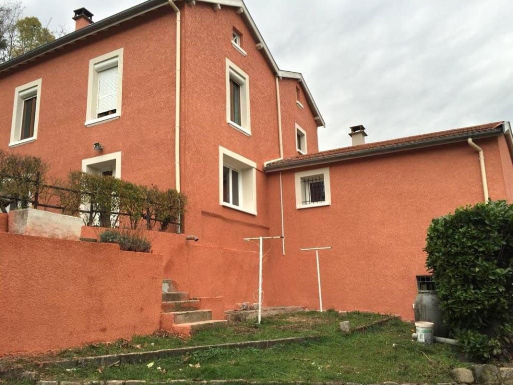Maison avec façade neuve rouge depuis la vue du jardin